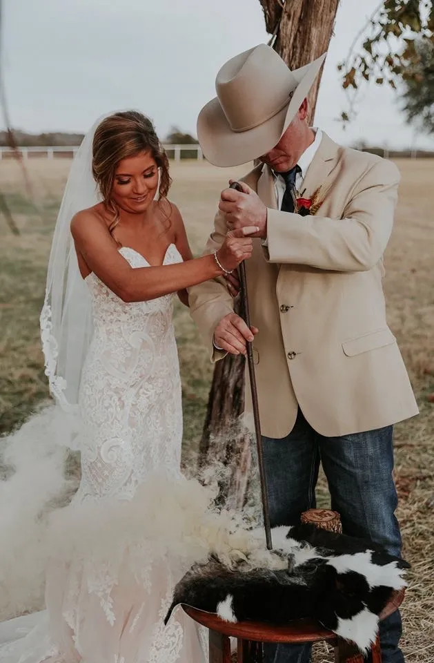 a bride and groom hold their dogs