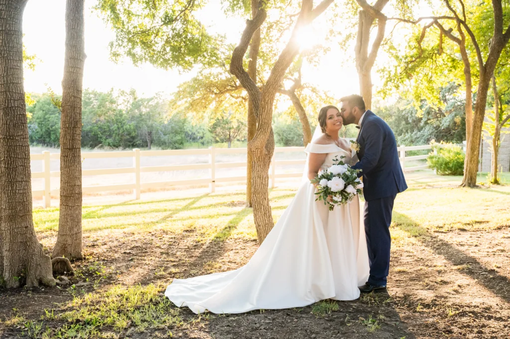 a bride and groom pose in the sunshine on their wedding day