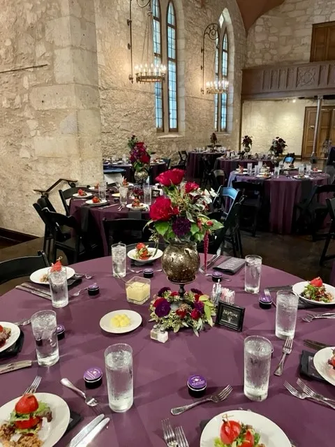 a plum-colored wedding reception table setting