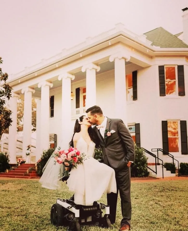 a bride and groom posing in front of their wedding venue