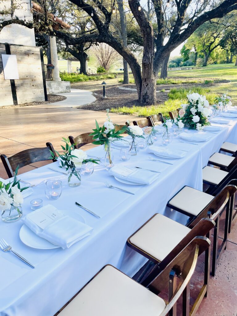 a long table at a wedding reception sits inside a grove at a wedding venue