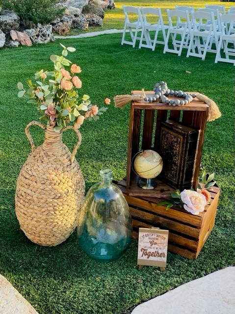 a photo of two wood crates sitting outside of a wedding ceremony with flowers