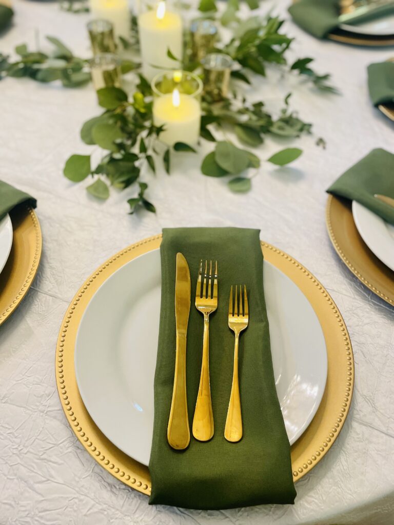 Sage green and gold wedding reception plates and napkins at a wedding venue in Austin