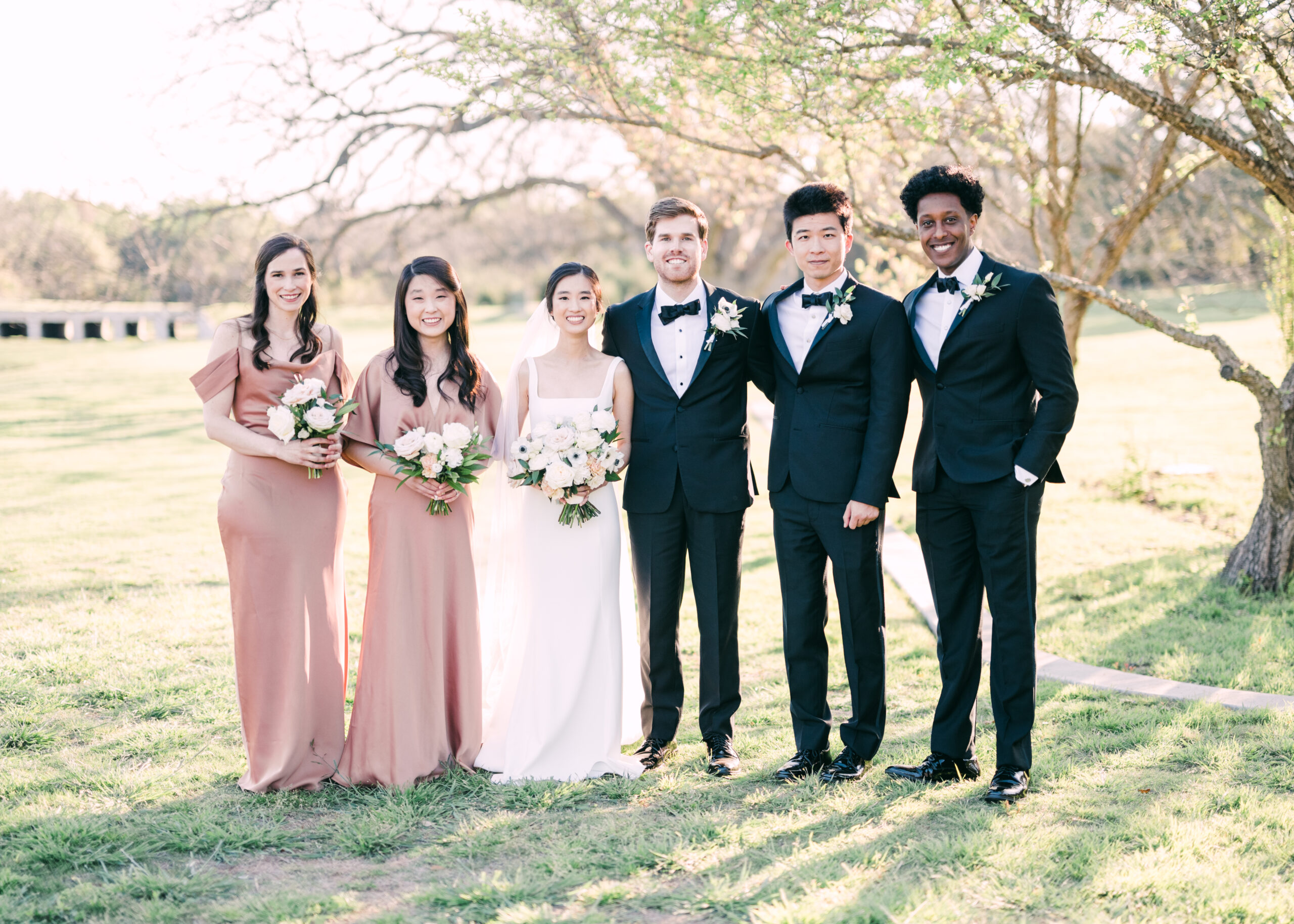 A bride and groom stands with their wedding party