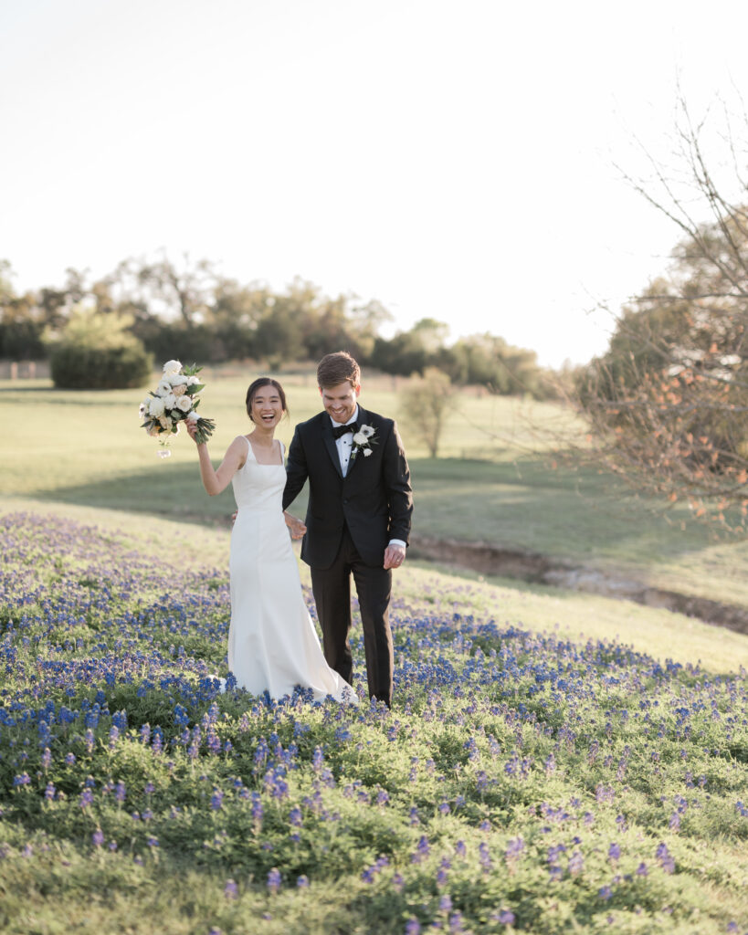 a couple walks in bluebonnets at Garey House wedding venue